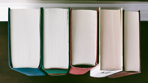 row of five hardcover books, only the tops are visible