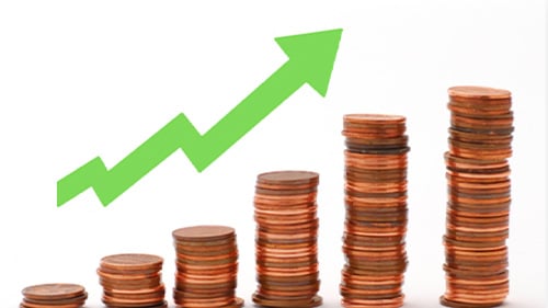 Stacks of pennies in increasing amounts. Above the pennies is a green arrow pointing upward. 