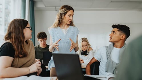 teacher explains concept to high school students