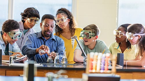 Science teacher helping high school students