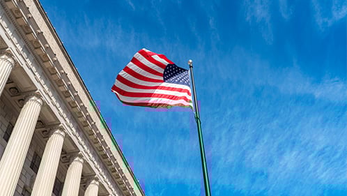 American flag waves next to the US Supreme Courthouse