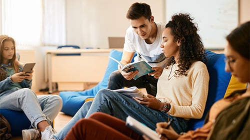 high school students sitting in group reading novels independently 