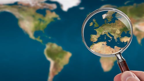 magnifying glass inspects world map