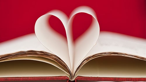 Open book with middle pages folded together in the shape of a heart