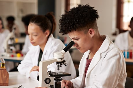 Boy working on biology with a microscope