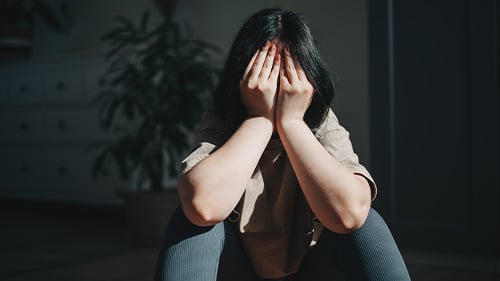 Girl with face in hands looking upset