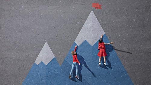 Elementary age students laying on chalk drawing of a mountain, pretending to climb it. 