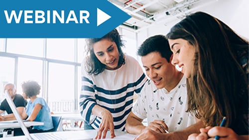 Teacher helping two high school students with an assignment