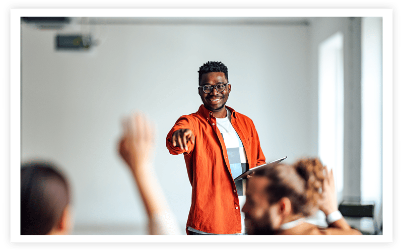 Classroom teacher calling on student with hand raised