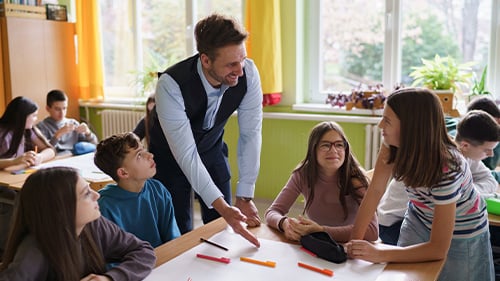 teacher talking to group of ELA students