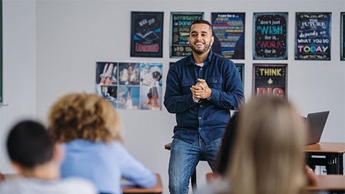 High school teacher speaking to class at front of the classroom