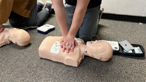Student practicing CPR on a dummy