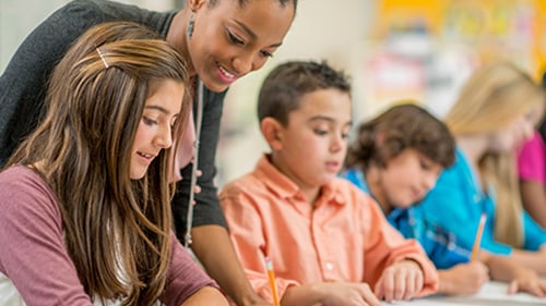 teacher helping student work on assignment