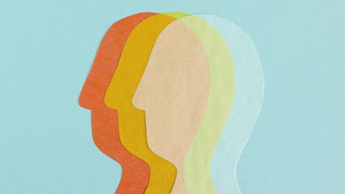 pieces of paper in the shapes of heads layered over each other