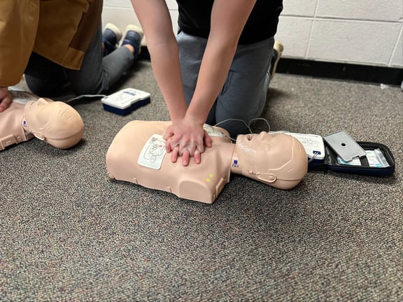 Student practicing CPR on a dummy