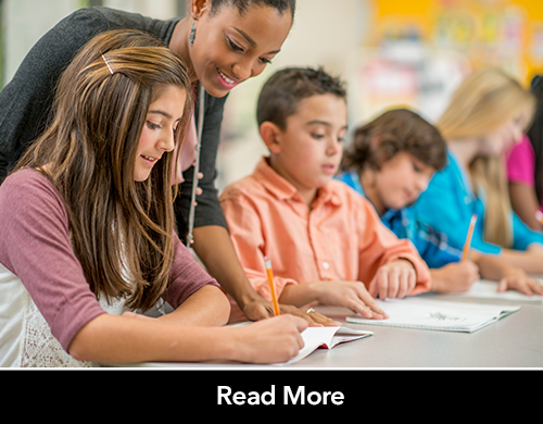 Teacher helping middle school students with vocabulary lesson